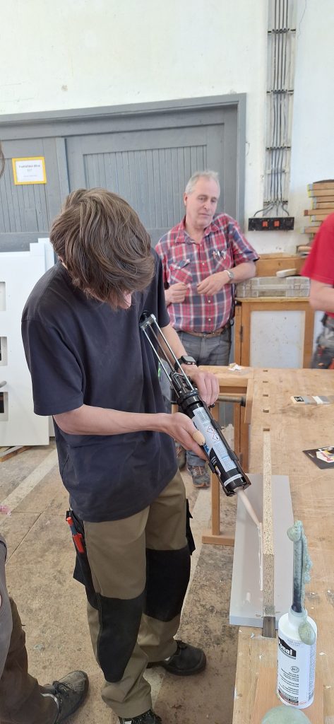 Žák si zkouší aplikaci tmelu pomocí vytlačovací pistole