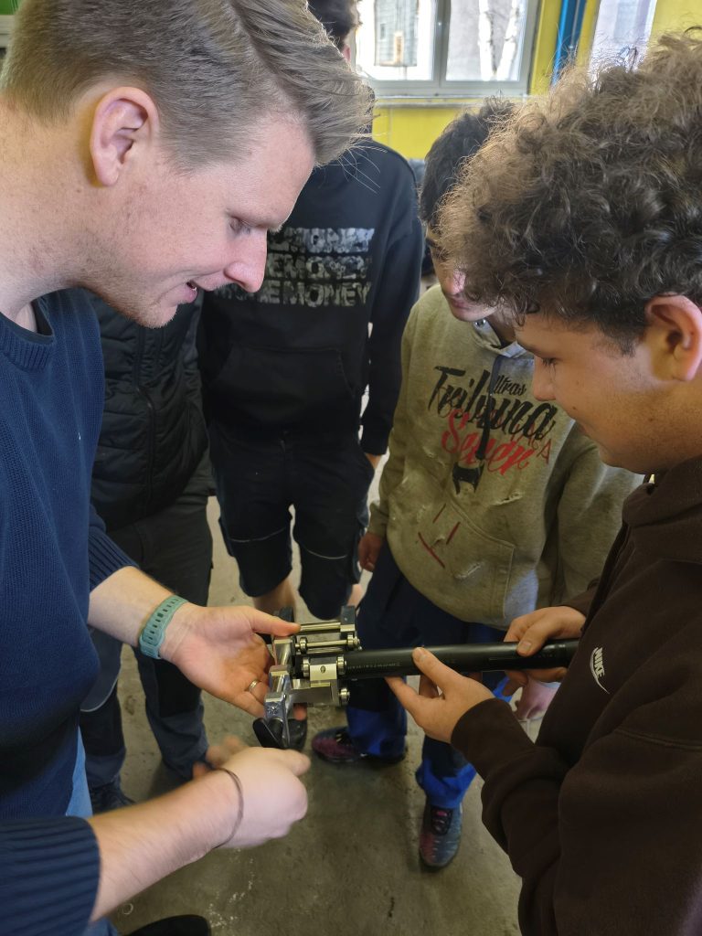 Student připojuje na eletrotvarovku kabely a připojuje svařovací zařízení.