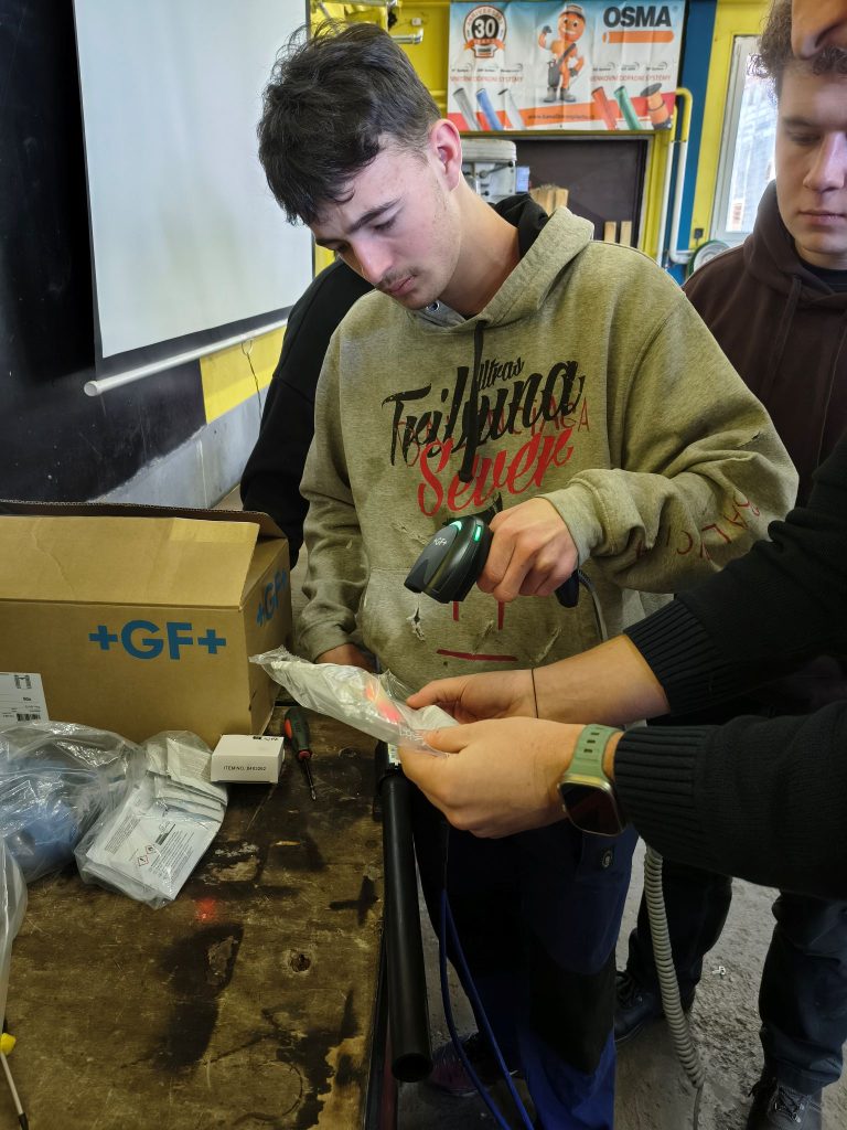 Student čtečkou čárových kódu načítá do svařovacího zařízení informace o tvarovce.