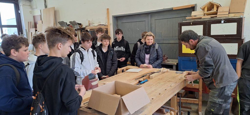 Učitel ukazuje, jak správně brousit dřevo