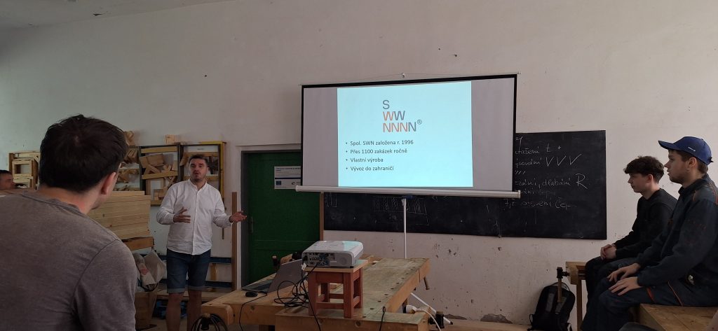 Odborník přednáší žákům před projekčním plátnem