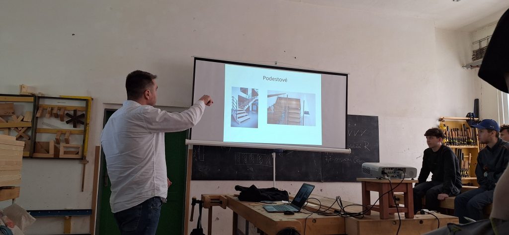 Odborník přednáší žákům před projekčním plátnem